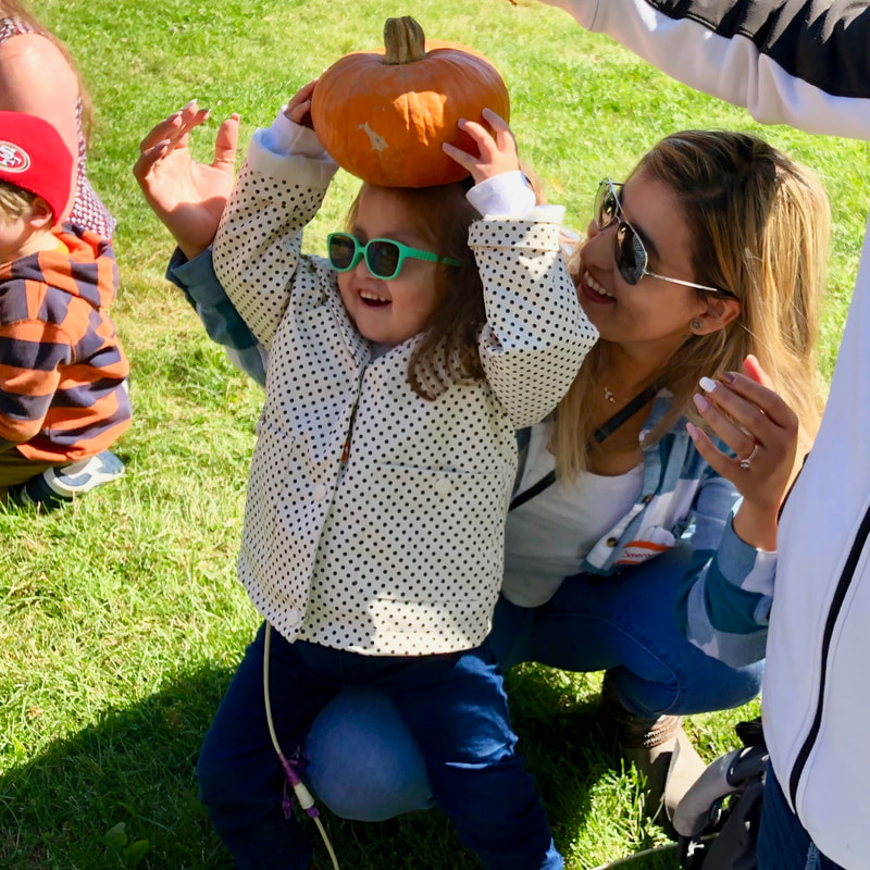 Picture of girl holding pumpkin on her head